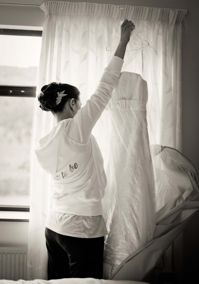bride hanging wedding dress